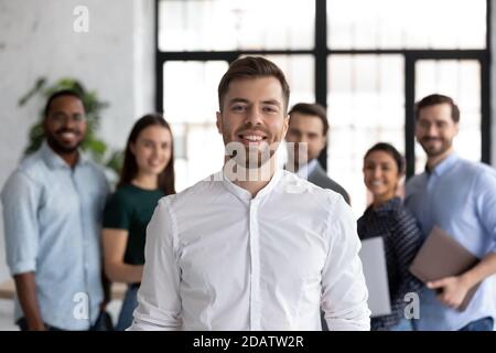Étudiant souriant posant devant un groupe de jeunes divers Banque D'Images