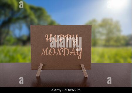 Carte Happy Monday sur la table avec fond de forêt verte ensoleillée. Banque D'Images