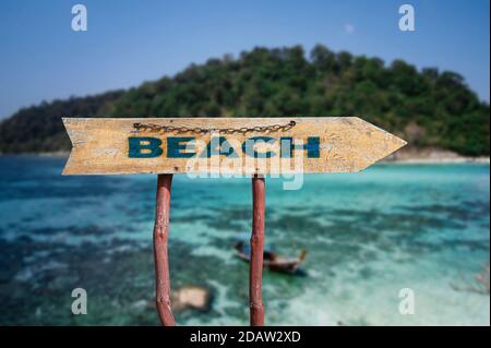 Beach flèche de route en bois signe contre la plage tropicale avec sable blanc et fond d'eau turquoise. Concept de voyage. Banque D'Images