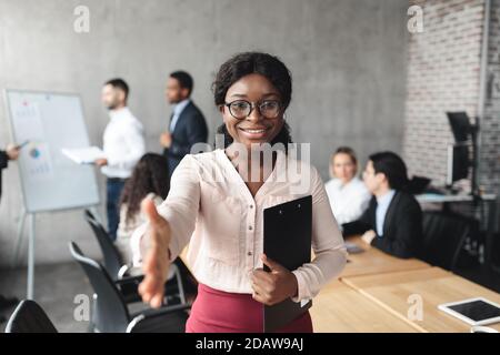 Une femme d'affaires africaine qui tient debout au bureau avec poignée de main Banque D'Images