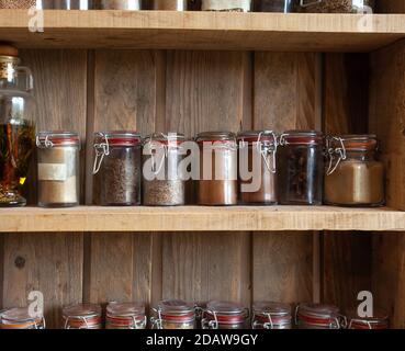 Bouteilles avec épices et assaisonnements dans un rack en bois. Différentes herbes biologiques pour dans la cuisine look vintage Banque D'Images