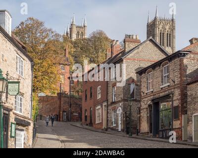 Vue sur la colline escarpée de Lincoln, une vieille ville médiévale attraction touristique par une journée tranquille avec 2 personnes Banque D'Images