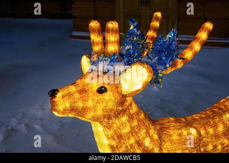 Figurine cerf en acrylique clair, décoration de Noël renne illuminée dans le parc d'hiver de la ville.