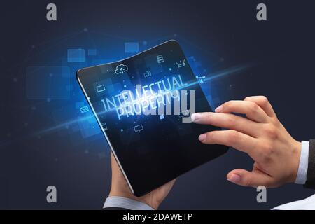 Businessman holding a smartphone pliable avec inscription de la propriété intellectuelle, la cyber sécurité concept