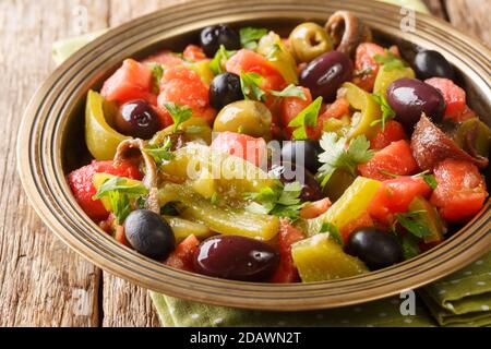 Salade délicieuse de tomates et poivrons verts Chlada felfel avec anchois et olives dans un bol sur la table. Horizontal Banque D'Images