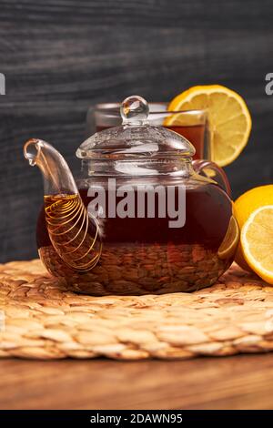 tasse de thé, théière en verre, citron sur une table en bois Banque D'Images