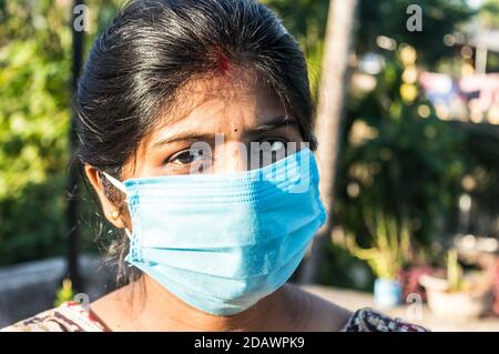 Masque souriant. Femme souriante portant un masque. Gros plan vue de face d'une femme indienne heureuse portant un masque souriant et regardant c Banque D'Images