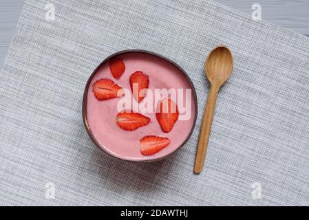 Bol de smoothie super-alimentaire pour le petit déjeuner sain recouvert de fraise. Gros plan. Délicieux bol de smoothie aux baies. Aliments crus végétaliens. Mise au point sélective. Mise à plat Banque D'Images