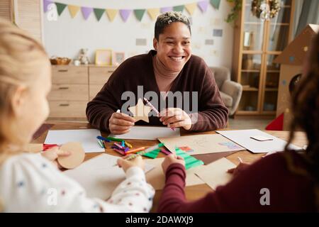 Portrait d'une enseignante souriante regardant les enfants pendant les cours d'art et d'artisanat à l'école, espace de copie Banque D'Images