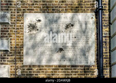 Les dégâts causés par les éclats de la Seconde Guerre mondiale à une plaque commémorant les militants anti-esclavagistes de la secte Clapham. Sur l'église de la Sainte Trinité, Clapham Common. Banque D'Images