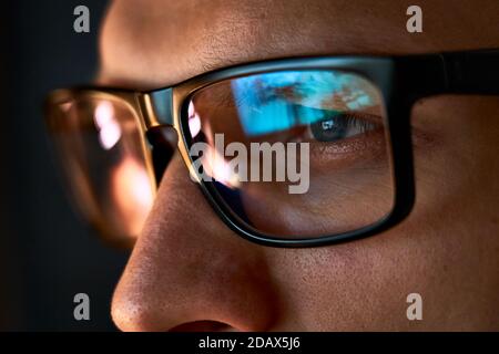 Gros plan sur un homme d'affaires ciblé portant des lunettes d'ordinateur regardant l'écran d'un pc. Banque D'Images
