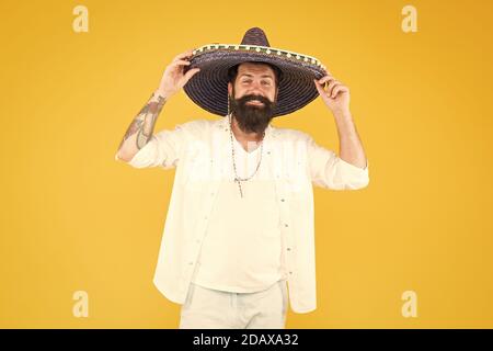 Célébrant la fête, un homme heureux porte un poncho. S'amuser en fête. Sombrero party man. Homme dans un chapeau de sombrero mexicain. Célébrez les traditions. Hipster avec barbe semble festif dans le sombrero. Banque D'Images