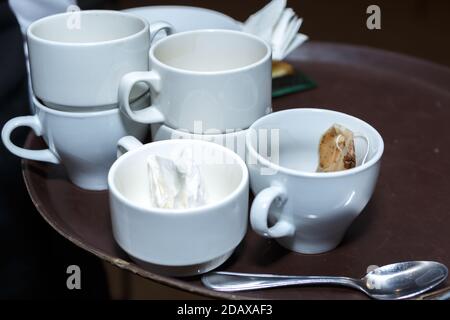 Utilisé du thé sale et des tasses à café sur un plateau fermé. Vaisselle sale Banque D'Images