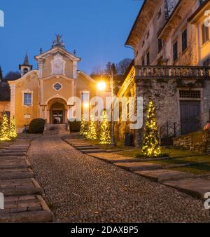 Les arbres de Noël illuminent la nuit dans les rues pavées médiévales d'Orta San Giulio, superbe village médiéval du Piémont.Italie Banque D'Images