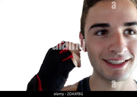 jeune homme souriant en mettant le petit casque bluetooth sur lui ear pour démarrer une session d'exercice avec l'espace de copie et arrière-plan blanc Banque D'Images