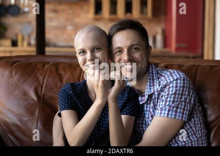 Mari aimant embrassant femme malade du cancer sur le canapé à la maison Banque D'Images