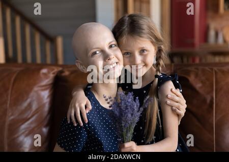Mère aimante malade du cancer et petite fille assise sur un canapé Banque D'Images