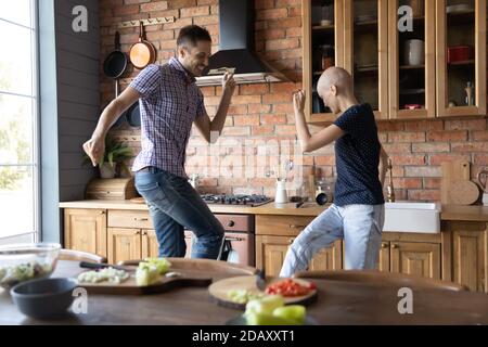 Un mari et une femme débordaient de joie à se battre contre la danse du cancer dans la cuisine Banque D'Images