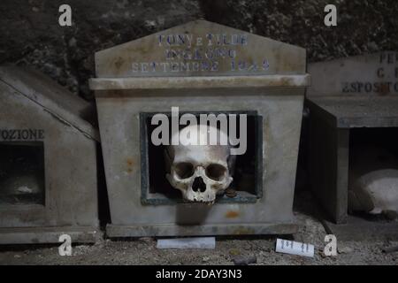 Crâne humain en boîte au cimetière Fontanelle (Cimitero delle Fontanelle) de Naples, Campanie, Italie. L'ancienne maison de charnel (ossuary) située dans une grotte dans le district de Materdei était l'endroit où le culte spontané de la dévotion aux restes de morts sans nom s'est développé à Naples. Les défenseurs du culte ont payé des visites aux crânes sans nom dans l'ossuaire pour les adopter et même donner les noms des crânes. Les crânes adoptés ont été placés à l'intérieur de la boîte décorée et sont devenus l'objet de prières régulières et d'offrande votive. Banque D'Images