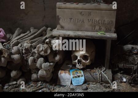 Crâne humain en boîte au cimetière Fontanelle (Cimitero delle Fontanelle) de Naples, Campanie, Italie. L'ancienne maison de charnel (ossuary) située dans une grotte dans le district de Materdei était l'endroit où le culte spontané de la dévotion aux restes de morts sans nom s'est développé à Naples. Les défenseurs du culte ont payé des visites aux crânes sans nom dans l'ossuaire pour les adopter et même donner les noms des crânes. Les crânes adoptés ont été placés à l'intérieur de la boîte décorée et sont devenus l'objet de prières régulières et d'offrande votive. Banque D'Images