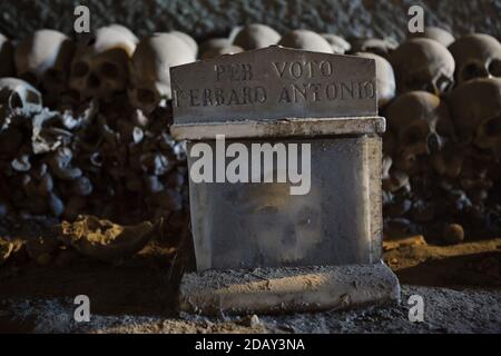 Crâne humain en boîte au cimetière Fontanelle (Cimitero delle Fontanelle) de Naples, Campanie, Italie. L'ancienne maison de charnel (ossuary) située dans une grotte dans le district de Materdei était l'endroit où le culte spontané de la dévotion aux restes de morts sans nom s'est développé à Naples. Les défenseurs du culte ont payé des visites aux crânes sans nom dans l'ossuaire pour les adopter et même donner les noms des crânes. Les crânes adoptés ont été placés à l'intérieur de la boîte décorée et sont devenus l'objet de prières régulières et d'offrande votive. Banque D'Images