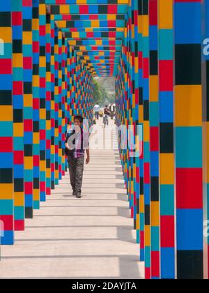 L'homme marche à travers l'arcade colorée à Mexico, Mexique Banque D'Images