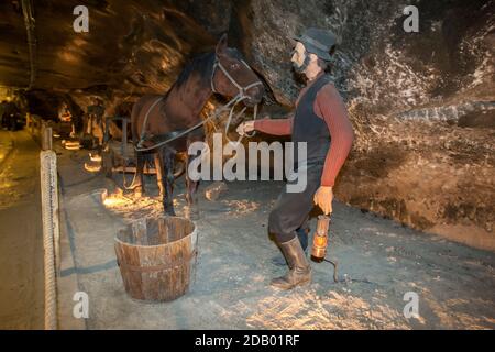 Un mannequin exposé dans la mine de sel de Wieliczka à Cracovie en Pologne montrant un homme qui dirige un cheval qui tire un chariot souterrain. Banque D'Images