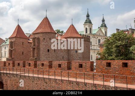 Une section des murs médiévaux qui entouraient autrefois Varsovie en Pologne. À droite, l'Église Sainte-Croix. Banque D'Images