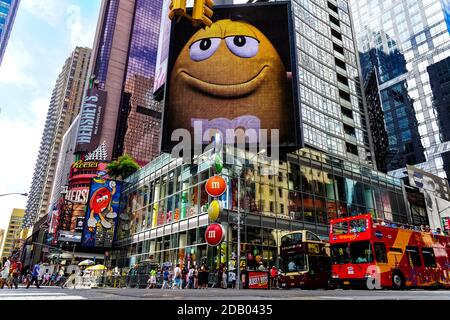 M&m'S World Store à côté de Times Square, avec des bus qui traversent des panneaux d'affichage colorés. Banque D'Images
