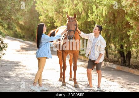 Jeune couple avec mignon cheval en plein air Banque D'Images