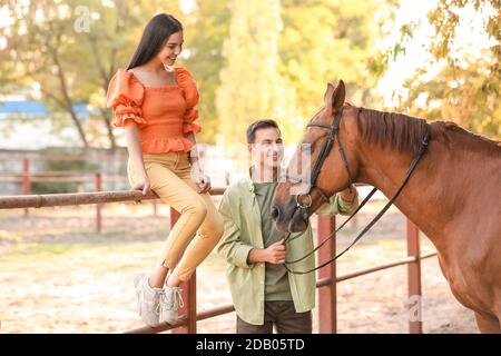 Jeune couple avec mignon cheval en plein air Banque D'Images