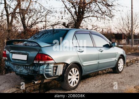 Une voiture sans pare-chocs, le tuyau d'échappement est visible. Le couvercle du coffre est bosselé. Auto après accident. Une réparation est nécessaire. Concept d'assurance automobile Banque D'Images