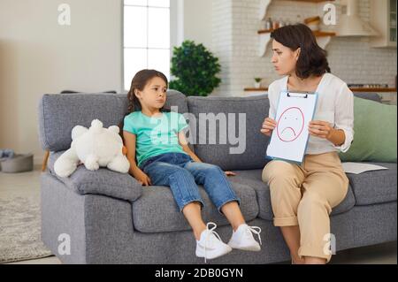 Enfant psychologue ayant séance de thérapie avec petite fille discutant et dépeignant les émotions Banque D'Images