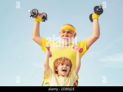 Éducation sportive. Le père et le fils. Un mode de vie familial sain. Garçon fait des exercices pour développer des muscles. Suivez le grand-père Banque D'Images