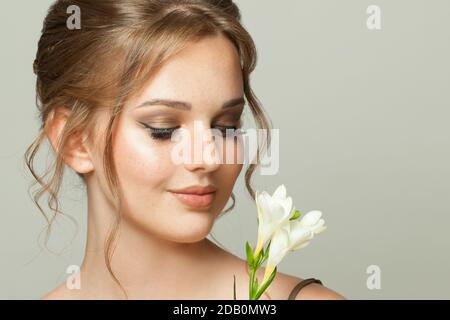 Belle jeune femme avec la peau naturelle claire et les taches de rousseur fleurs blanches Banque D'Images