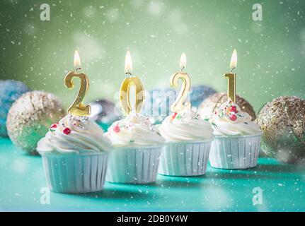 Bougies dorées en forme de chiffres 2021 sur cupcakes. Joyeux nouvel an, Joyeux Noël et la saison d'hiver concept de salutations. Copier l'espace Banque D'Images
