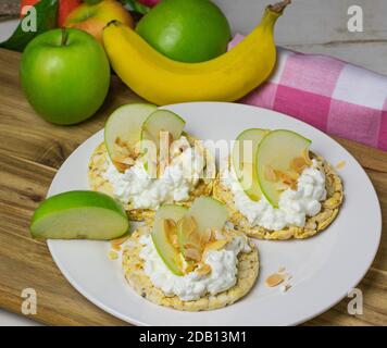 une assiette de gaufres de riz surmontée de fromage cottage, de pommes, de tranches de sirop d'érable Banque D'Images