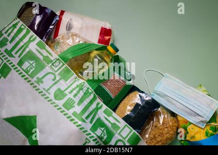 Approvisionnement alimentaire de crise pour la période d'isolement en quarantaine pendant la pandémie du coronavirus. Un ensemble de produits dans un sac en papier : riz, pâtes, flocons d'avoine, sug Banque D'Images