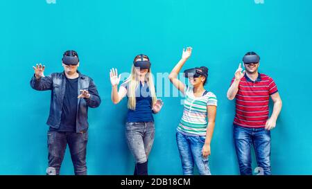 Groupe d'amis multiethniques utilisant la nouvelle technologie jouant sur vr lunettes intérieures Banque D'Images