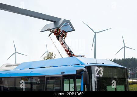 Le bus électrique à un arrêt est chargé par pantographe Banque D'Images