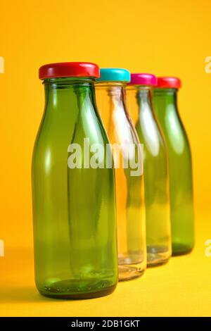 30 octobre 2020, quatre flacons en verre vides avec bouchons à vis de couleur devant un fond jaune comme symbole pour une utilisation dans le monde entier, par exemple Banque D'Images