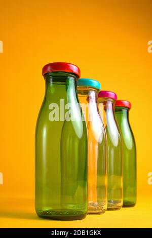 30 octobre 2020, quatre flacons en verre vides avec bouchons à vis de couleur devant un fond jaune comme symbole pour une utilisation dans le monde entier, par exemple Banque D'Images