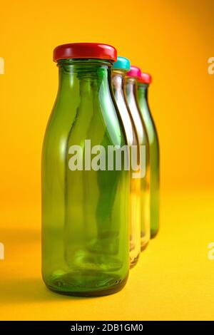 30 octobre 2020, quatre flacons en verre vides avec bouchons à vis de couleur devant un fond jaune comme symbole pour une utilisation dans le monde entier, par exemple Banque D'Images