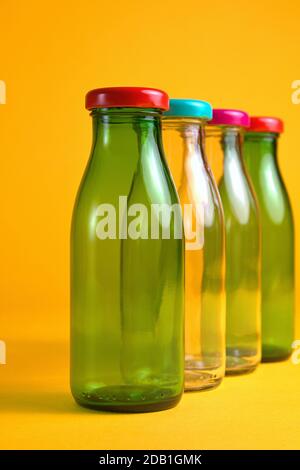 30 octobre 2020, quatre flacons en verre vides avec bouchons à vis de couleur devant un fond jaune comme symbole pour une utilisation dans le monde entier, par exemple Banque D'Images