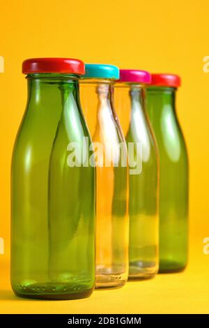 30 octobre 2020, quatre flacons en verre vides avec bouchons à vis de couleur devant un fond jaune comme symbole pour une utilisation dans le monde entier, par exemple Banque D'Images