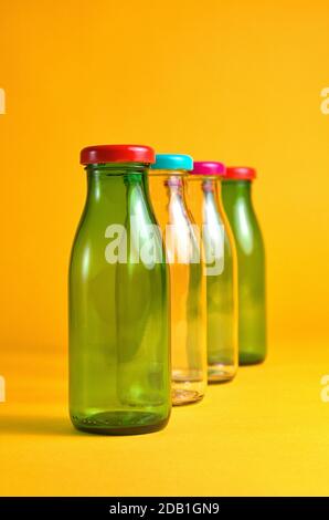 30 octobre 2020, quatre flacons en verre vides avec bouchons à vis de couleur devant un fond jaune comme symbole pour une utilisation dans le monde entier, par exemple Banque D'Images