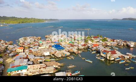 Village de pêcheurs avec maisons sur l'eau, avec bateaux de pêche. Village de pêcheurs avec maisons en bois sur pilotis dans la mer. Philippines, Mindanao. Banque D'Images