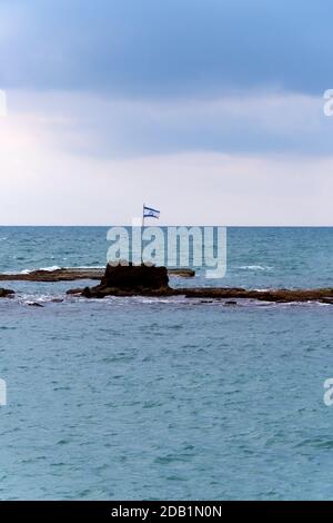 Drapeau d'Israël sur les rochers de la mer près de la côte de tel Aviv. Histoire, culture, politique israéliennes, célébration du jour de l'indépendance, concepts d'identité. Banque D'Images