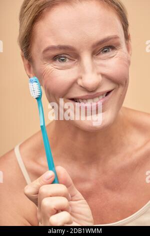 Bonne jolie femme va se brosser les dents Banque D'Images