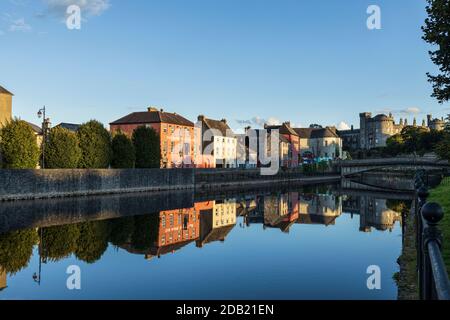 Le Home Rule Club, et le château de Kilkenny se reflétant dans les eaux de la rivière Nore lors d'une soirée d'été claire, comté de Kilkenny, Irlande Banque D'Images